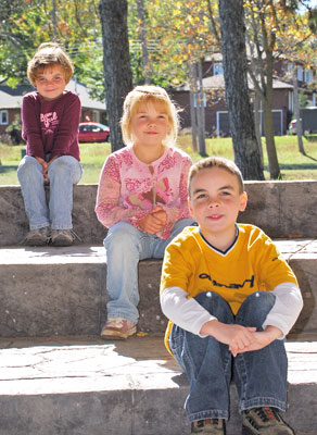 three children sitting on steps